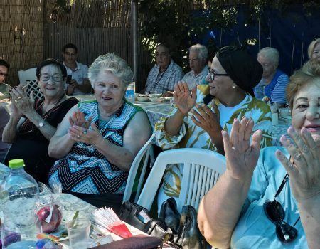 קשישים וניצולי שואה בודדים נהנים משירי ראש השנה בסעודה שחסדי נעמי ערכו